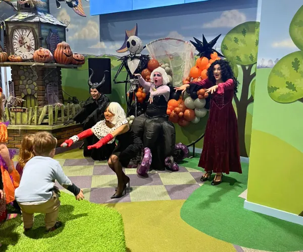 Costumed characters greet an excited young child at a Fun Street meet and greet event