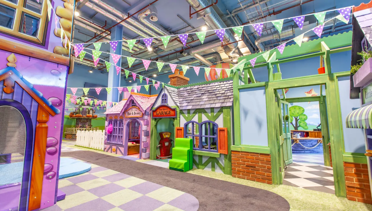 Painted storybook houses with bunting strung across the play street at Fun Street, Silverburn